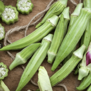 Fresh green okra pods arranged on a wooden surface.